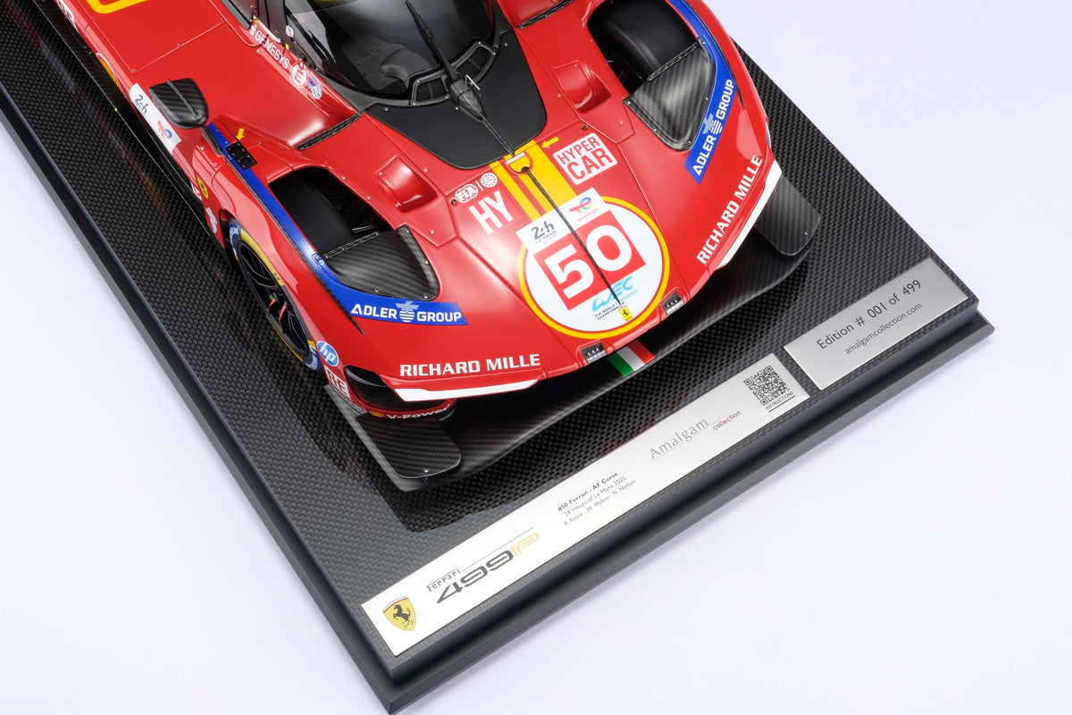A red and yellow Ferrari 499P 2025 Le Mans racing car at 1.8 scale with multiple sponsors, displayed on a light surface against a light background.