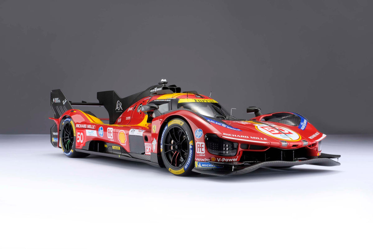 A red and yellow Ferrari 499P 2025 Le Mans racing car at 1.8 scale with multiple sponsors, displayed on a light surface.