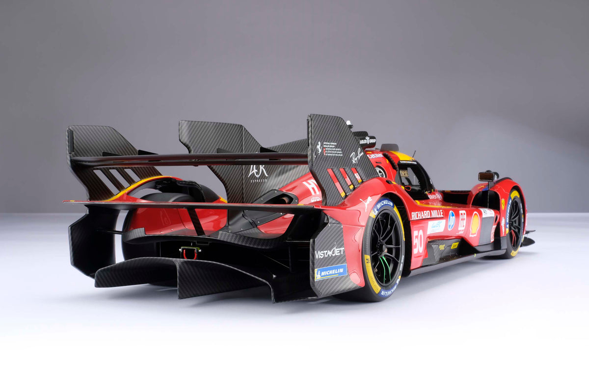 A red and yellow Ferrari 499P 2025 Le Mans racing car at 1.8 scale with multiple sponsors, displayed on a light surface.