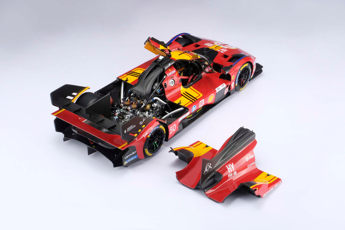 A top down shot of a Ferrari 499P 2025 Le Mans racing car at 1.8 scale with multiple sponsors showing the opening parts feature of the model, displayed on a light surface.