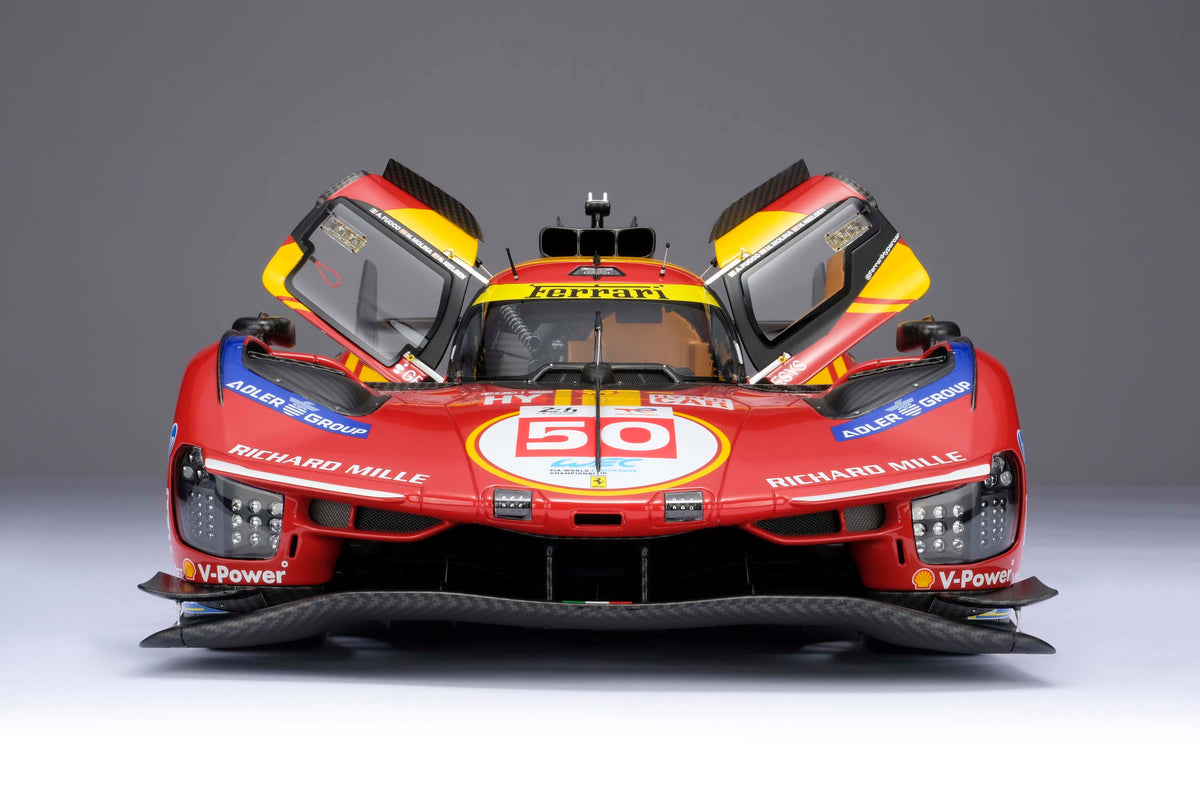 A shot of the front of a Ferrari 499P 2025 Le Mans racing car at 1.8 scale showing the opening door feature of the model, displayed on a light surface.