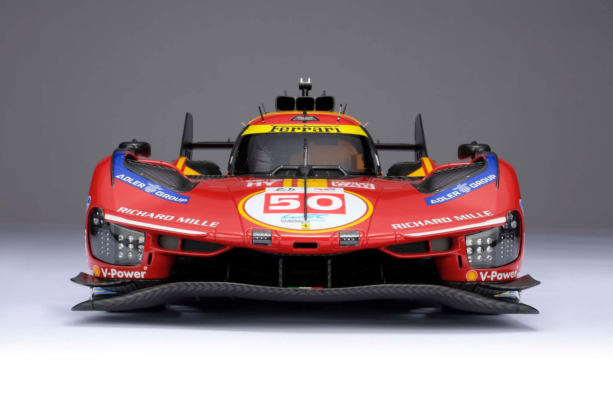 A red and yellow Ferrari 499P 2025 Le Mans racing car at 1.8 scale with multiple sponsors, displayed on a light surface against a light background.