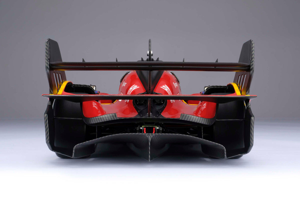 A red and yellow Ferrari 499P 2025 Le Mans racing car at 1.8 scale with multiple sponsors, displayed on a light surface.