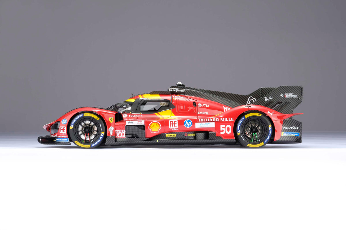 A red and yellow Ferrari 499P 2025 Le Mans racing car at 1.8 scale with multiple sponsors, displayed on a light surface.