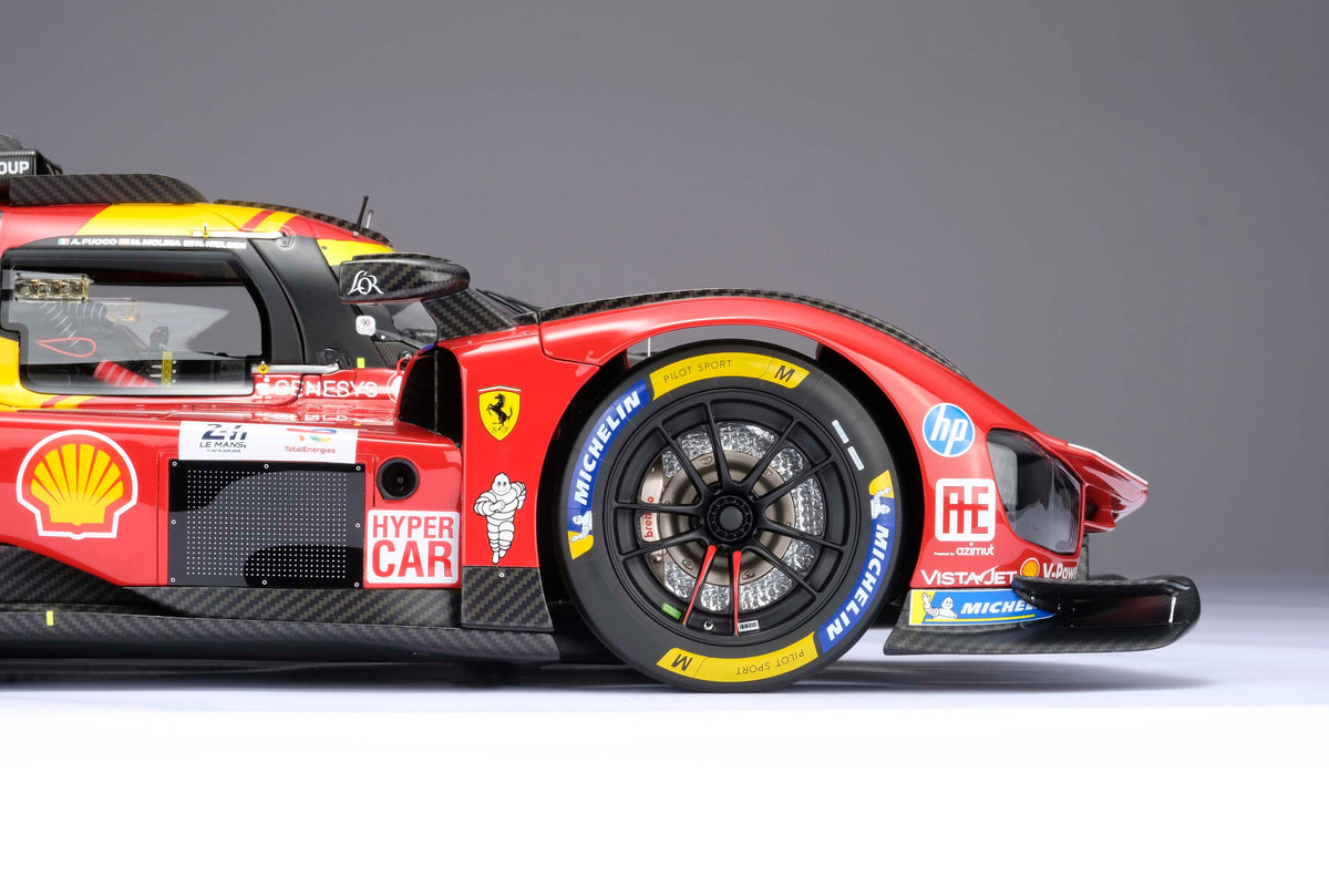A close up shot of the front section of a red and yellow Ferrari 499P 2025 Le Mans racing car at 1.8 scale with multiple sponsors, displayed against a light background.