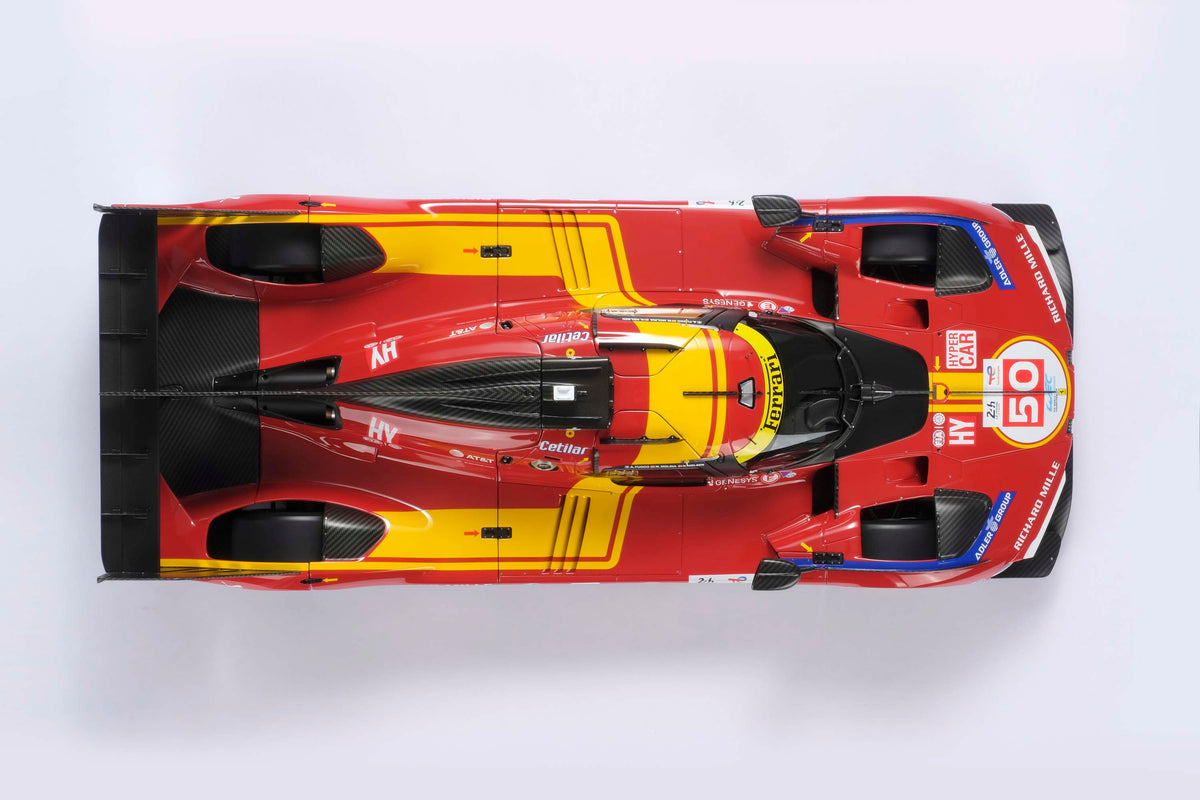 A top down shot showing the length of a Ferrari 499P 2025 Le Mans racing car at 1.8 scale with multiple sponsors, displayed on a light surface.