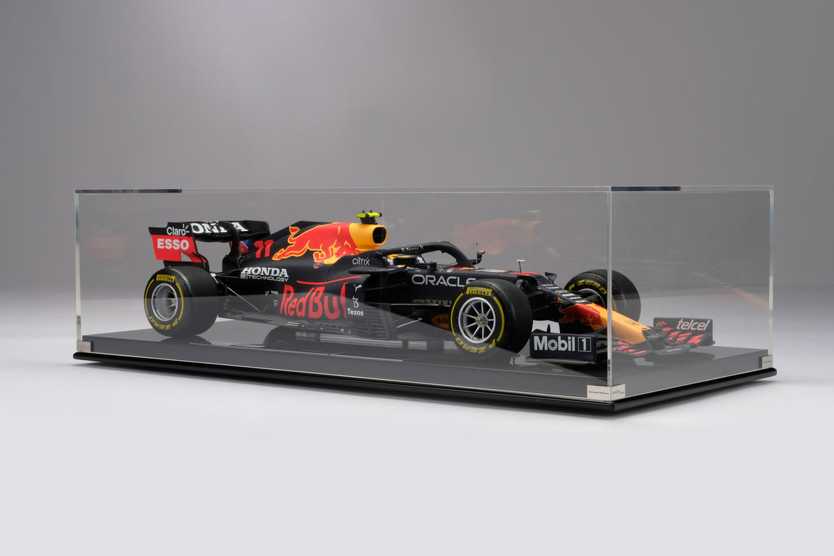 A shot of a 1:8 scale model of Sergio Perez's Red Bull Racing Honda RB16B inside an acrylic display box, presented against a neutral background.
