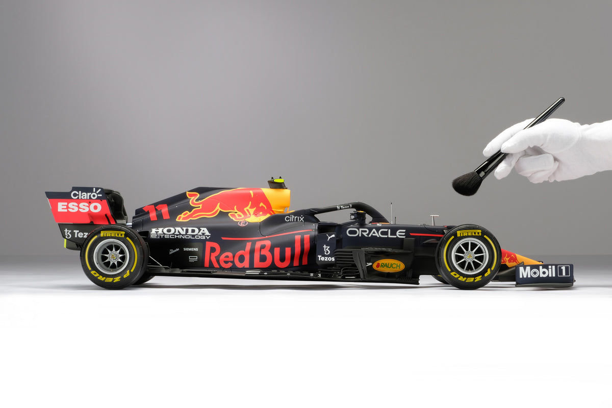 A 1:8 scale model of Sergio Perez's Red Bull Racing Honda RB16B on a neutral background, complete with hand and brush to show scale